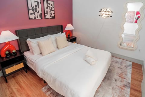 Comfortable bedroom featuring a soft bed, warm lighting, and modern artwork. The calming color palette and thoughtful layout create a relaxing space ideal for recharging and enjoying quiet moments during your stay.