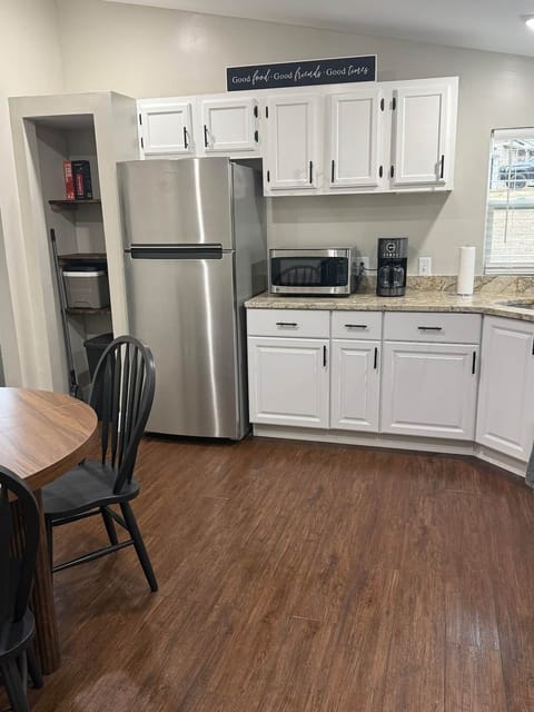 Coffee maker, microwave, and refrigerator. Pantry with fire extinguisher, trash can, mop, broom, and cooler. 