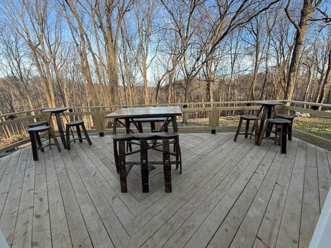 Large back deck with tables and stools made from whiskey barrels 