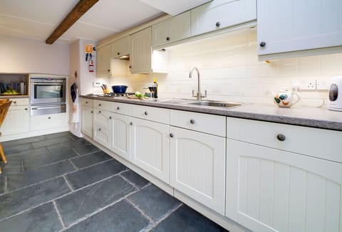 Hardys, Padstow. Ground Floor: Kitchen with an electric oven, gas hob, microwave, fridge, dishwasher, and Nespresso coffee machine