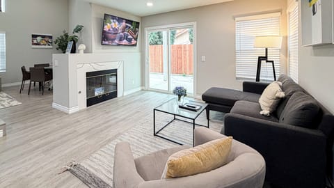 Bright living room with plush sectional seating, modern decor, & natural light.