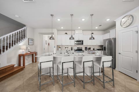 Gather in the stylish open kitchen-large quartz island with seating for five, sleek pendants, and ample cabinetry make meals a breeze.