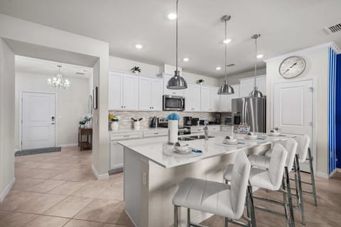 Bright and modern kitchen with pendant lighting, stainless appliances, and sleek quartz counters. The island seats four for easy breakfasts and prep space galore.
