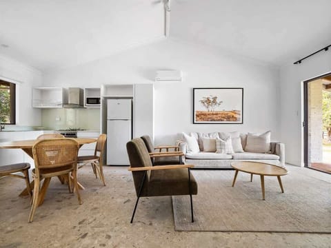 Bright and open living space featuring a modern kitchen with full amenities, a cozy lounge area with comfortable seating, and stylish décor.