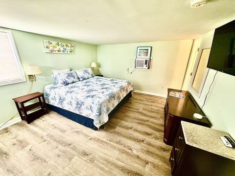 Rest peacefully in your bright, comfortable bedroom with coastal-inspired bedding, modern furnishings, and convenient amenities for a perfect stay.