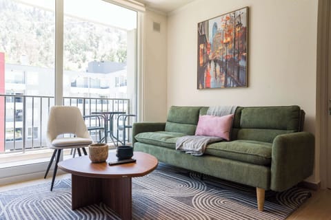 Relax in this stylish living room with a comfy sofa and vibrant cityscape art, perfect for unwinding after exploring the city.