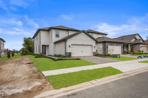 Modern suburban home with spacious driveway and lush front lawn.