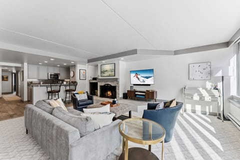 Unwind in your stylish living space with cozy fireplace, modern kitchen, and comfortable seating perfect for mountain getaway relaxation.