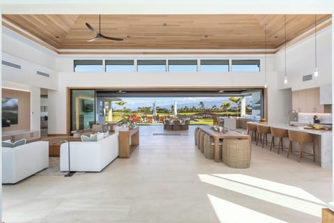 Relax in your stunning open-concept living space where indoor luxury meets outdoor paradise through soaring glass doors.