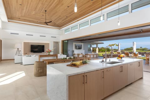 Your spacious open-plan kitchen flows into the living area, where warm wood and marble create an elegant cooking space.