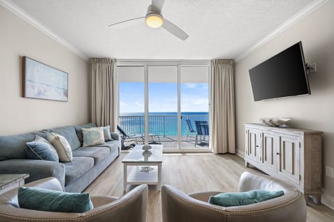 Relax in your beautifully appointed living room with panoramic ocean views through floor-to-ceiling windows and coastal-inspired decor.