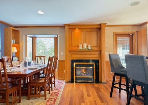 Enjoy elegant family dinners by the warmth of the fireplace in this classic wood-paneled dining space.