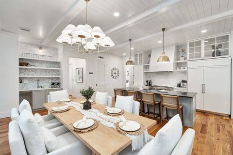 Your stunning open-plan kitchen flows seamlessly into the dining area, where you can savor meals under elegant pendant lighting and exposed beams.