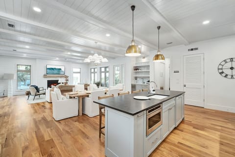 You'll love cooking in this stunning open-concept kitchen with gleaming marble countertops, brass pendant lights, and seamless flow to your elegant living space.