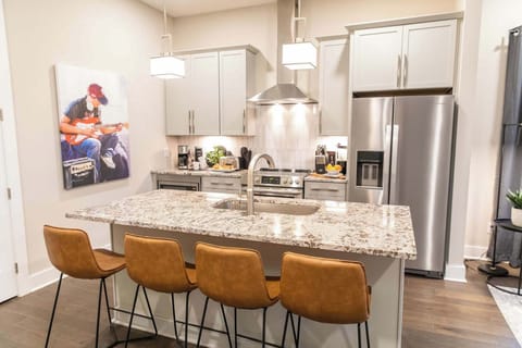 Granite island, stainless appliances, and colorful guitar art make this kitchen a showstopper.