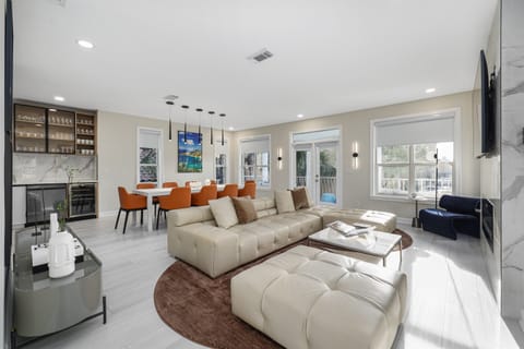 H2O Living offers a Large, Open Living Area on the 2nd Floor with a Leather Sectional, 65" Smart TV, Electric Fireplace, Dining Space, Remodeled Kitchen, and Patio with partial Gulf Views