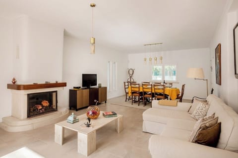 The lounge area invites you to unwind with its comfortable sofa bed, TV, and decorative fireplace, while the dining table for eight is perfect for family meals and lively conversations.