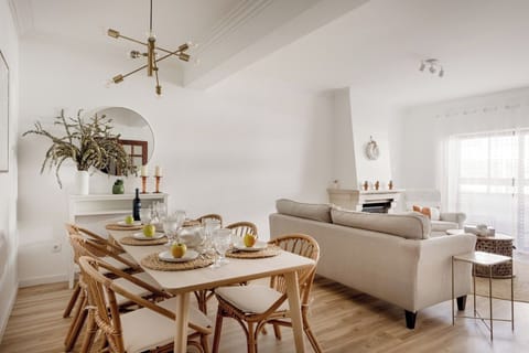 Living room with TV and dining table. Opens onto an enclosed balcony - a bright little retreat.