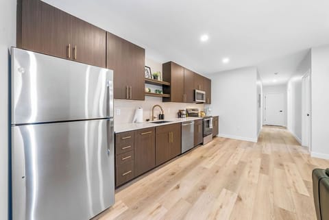 Your modern kitchen awaits with sleek stainless steel appliances and rich wood cabinetry, where meal prep becomes a pleasure on pristine counters.