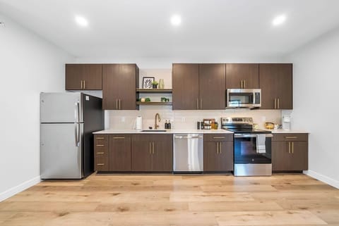 Your sleek modern kitchen awaits with stainless steel appliances and warm wood cabinets, perfect for creating memorable meals during your stay.