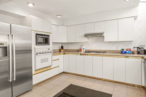 Spacious kitchen with refrigerator, microwave, gas stove, and cooking essentials