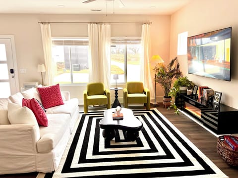 Sunny modern living room with open layout, smart TV, electric fireplace and plush seating.