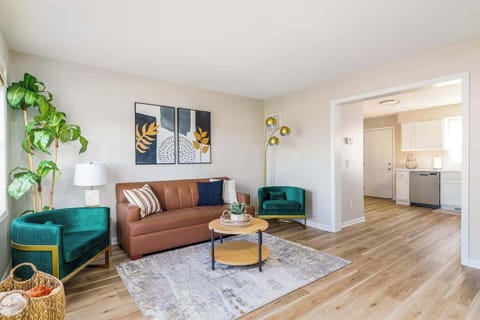 Bright living room w/ cozy seating, warm wood floors & natural light throughout