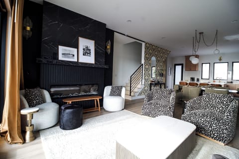 Open main living area with fireplace, generous seating, and view of the kitchen