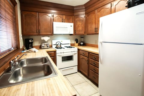 The full kitchen boasts rustic wood cabinetry and modern appliances, perfect for preparing hearty meals after a day in the mountains.