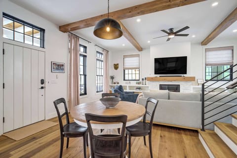 This centrally located dining area features a stylish round table perfect for group meals and conversation. The space transitions effortlessly into the fully stocked kitchen and offers a convenient view across the entire open main floor.