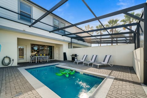 Resort-style screened lanai with private pool, sun loungers, BBQ grill, and covered outdoor dining-perfect for lazy Florida days.