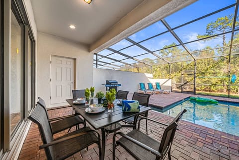 Covered lanai for alfresco dining (seats six), a grill, and your own screened-in pool with sunny loungers and tranquil nature views-relax and play all day.