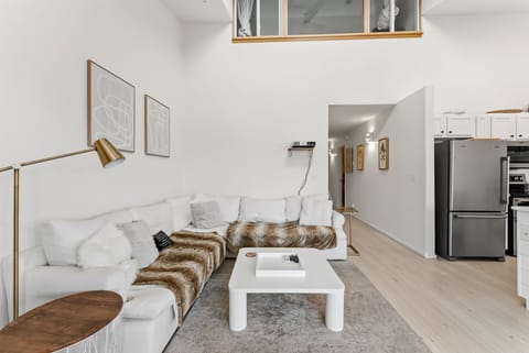 Sink into this stylish white sectional with cozy fur throws, perfect for relaxing after exploring the city.