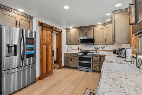 Your gourmet kitchen awaits with granite counters, stainless steel appliances, and rustic barn doors—perfect for creating memorable meals together.