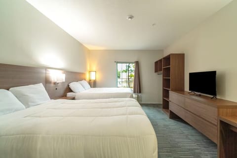 Wake up refreshed in airy double-queen room with sunny window.