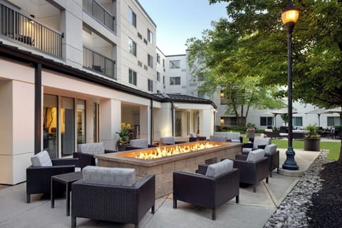 Gather outside as the firepit flickers under open skies.
