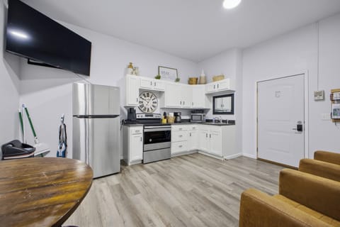 Bright kitchenette with stainless appliances, TV, and dining nook
