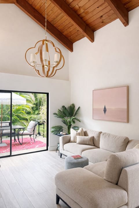 Sunlit living room opens straight to the tropical patio and backyard
