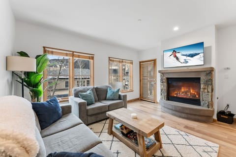 Cozy up by your warm fireplace while watching the big screen TV in this inviting living room with plush seating.