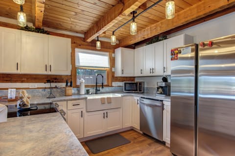 Cook your favorite meals in this rustic-modern kitchen with stainless steel appliances, granite counters, and warm wood beam ceiling.