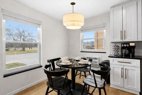Gather in this bright dining nook with modern seating, stylish lighting, and a fully equipped kitchen—perfect for meals, coffee, or casual conversation.