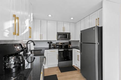 Cook with ease in this sleek, fully equipped kitchen featuring modern appliances, ample counter space, and bright cabinetry for a clean, inviting feel.