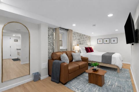 Bright, stylish studio with a plush bed, cozy seating area, smart TV, and warm finishes—designed for comfort, relaxation, and an easy stay.