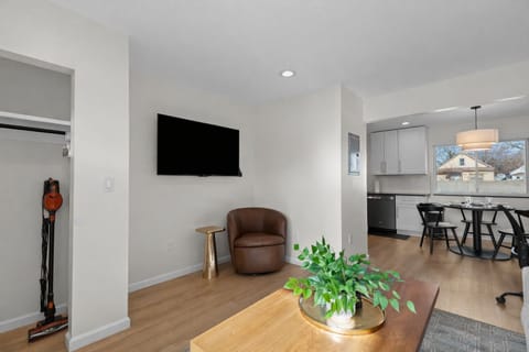 Relax in this bright living area featuring a comfy lounge chair, smart TV, and open flow to the kitchen and dining spaceâperfect for unwinding or entertaining.