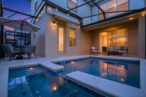 Twilight poolside perfection: spacious pool, spa, outdoor dining, and grill