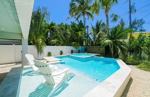 Spend slow afternoons floating or lounging beside the crystal-clear pool, framed by lush palms and bright blue skies. This peaceful outdoor space invites you to unwind, cool off, and fully settle into vacation mode