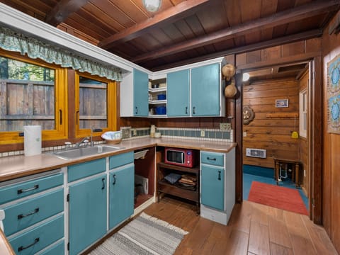 Cook up mountain memories in this charming rustic kitchen with turquoise cabinets, exposed beams, and authentic alpine character.