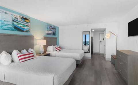 Unwind in airy double-queen comfort with serene beach tones.