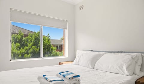 Comfortable double bedroom with large window views and neatly prepared linens.
