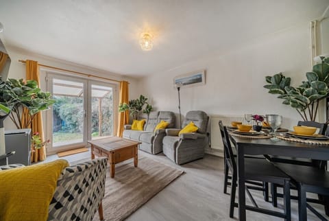 Bright open-plan lounge and dining area with garden doors flooding the room with light.